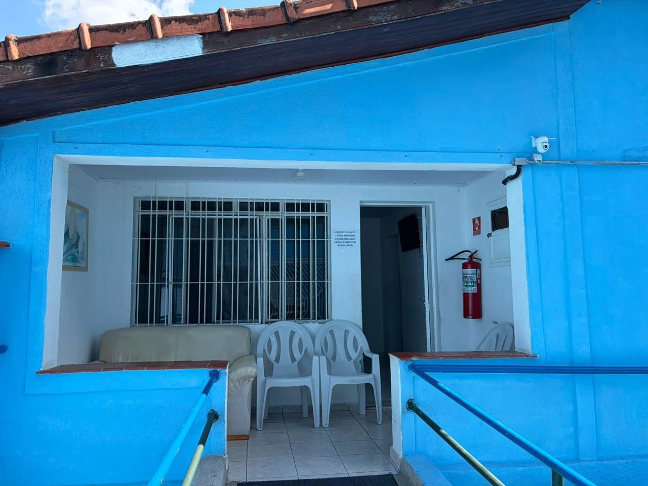Varanda de entrada com cadeiras e barras de apoio