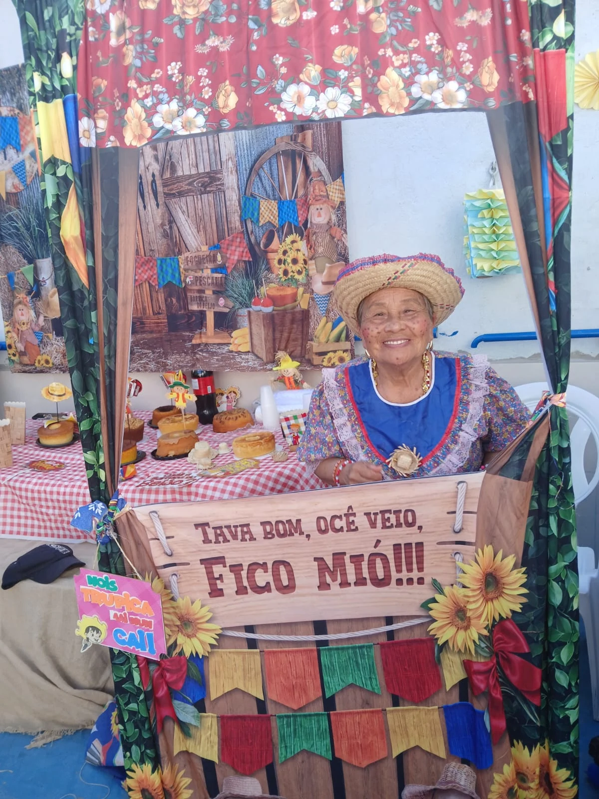 Sorriso de uma residente no cenário do encontro junino
