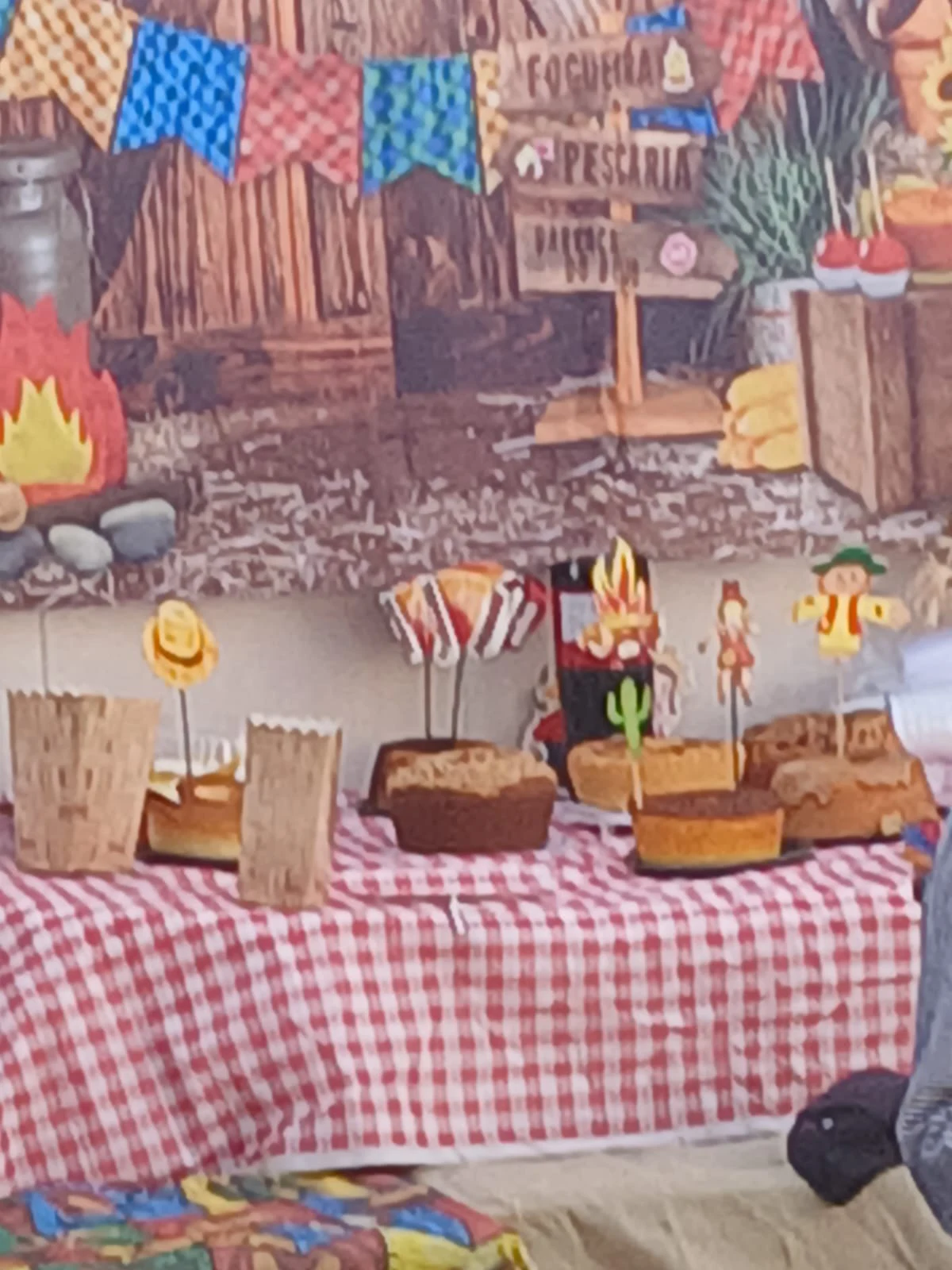 Mesa com bolos e decoração junina preparada para o encontro