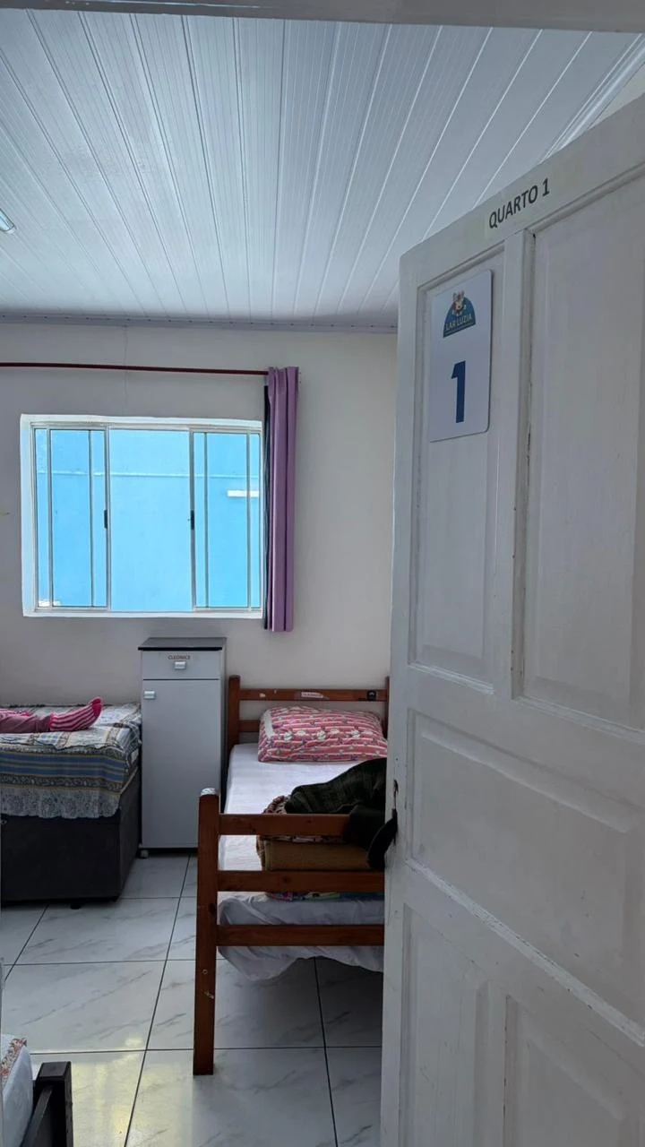 Quarto identificado com camas e janela
